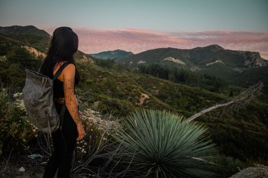 Woman in Black Tank Top and Black Pants Standing on Green Grass