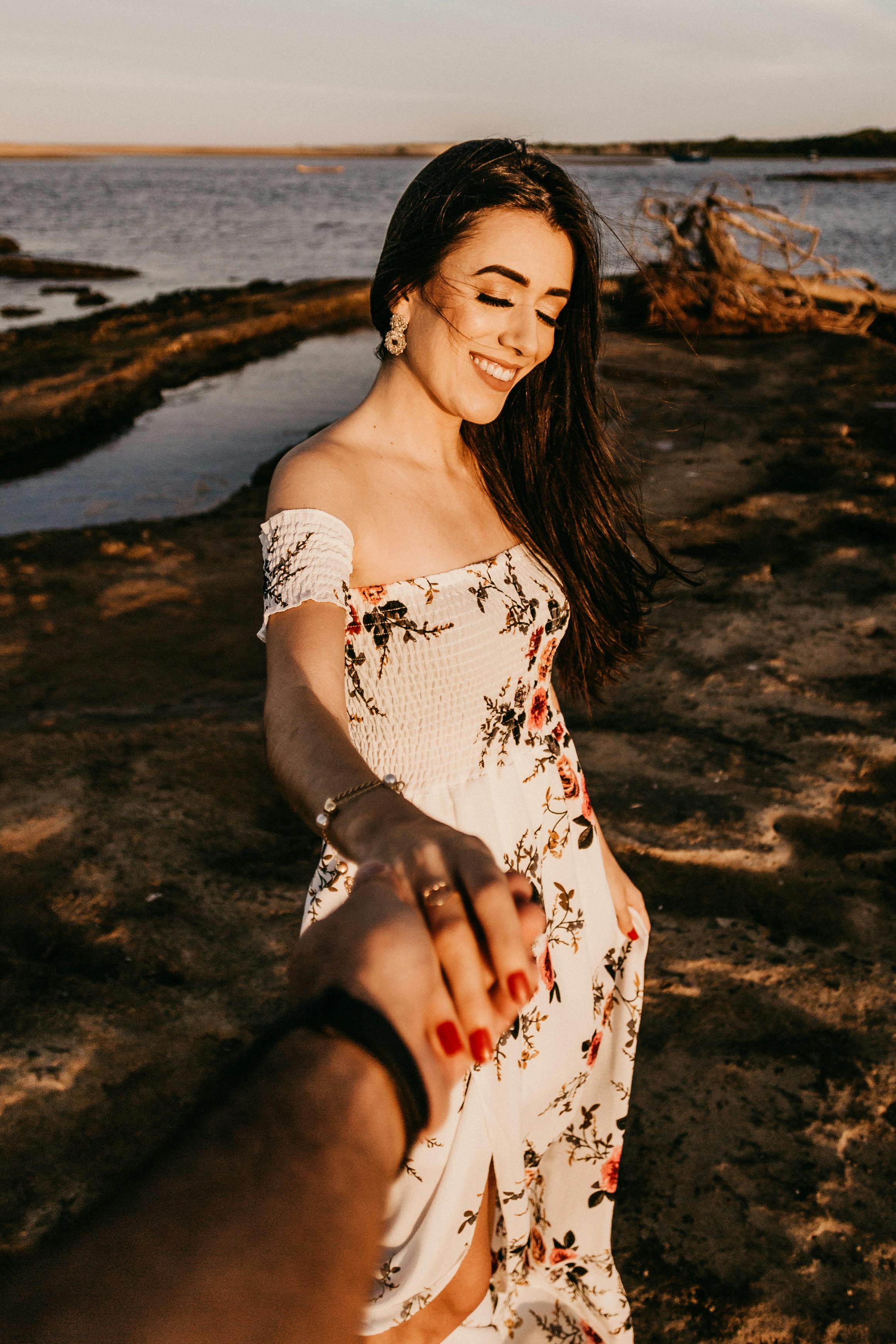 delighted woman holding boyfriends hand on scenic river bank