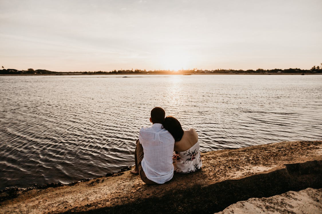 Un couple assis devant une rivière