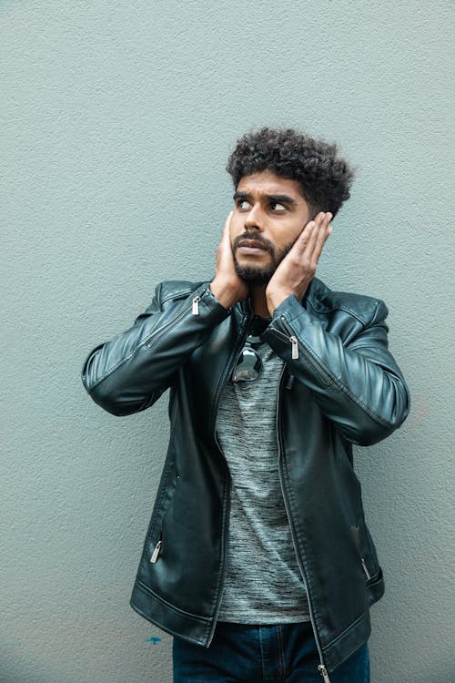 Man in Black Leather Jacket Covering his Ears