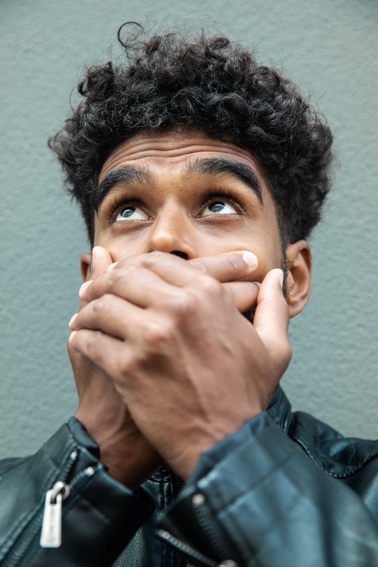 Man Wearing A Jacket Covering His Mouth