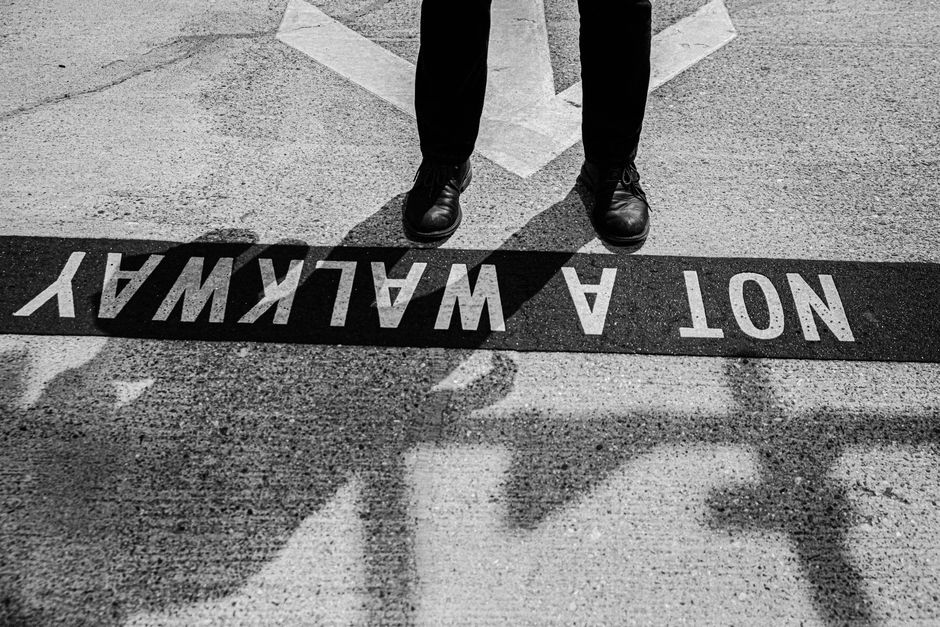 Creative street photography of asphalt with shadows and a 'NOT A WALKWAY' sign.
