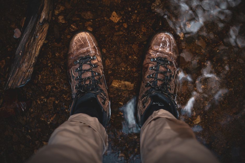 Close-up of hiking boots standing in a shallow stream, capturing the essence of outdoor adventure. Close-up of hiking boots standing in a shallow stream, capturing the essence of outdoor adventure.