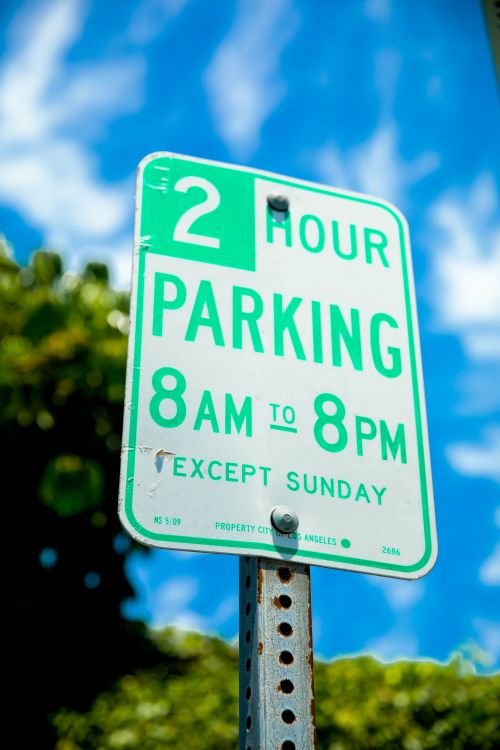 Free Green and white 2-hour parking street sign, clear blue sky background. Stock Photo