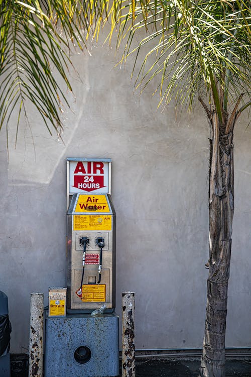 Free Air Pump Station Beside a Palm Tree Stock Photo