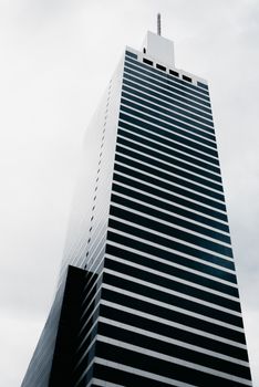 多云天空下，现代摩天大楼的低角度动态视图