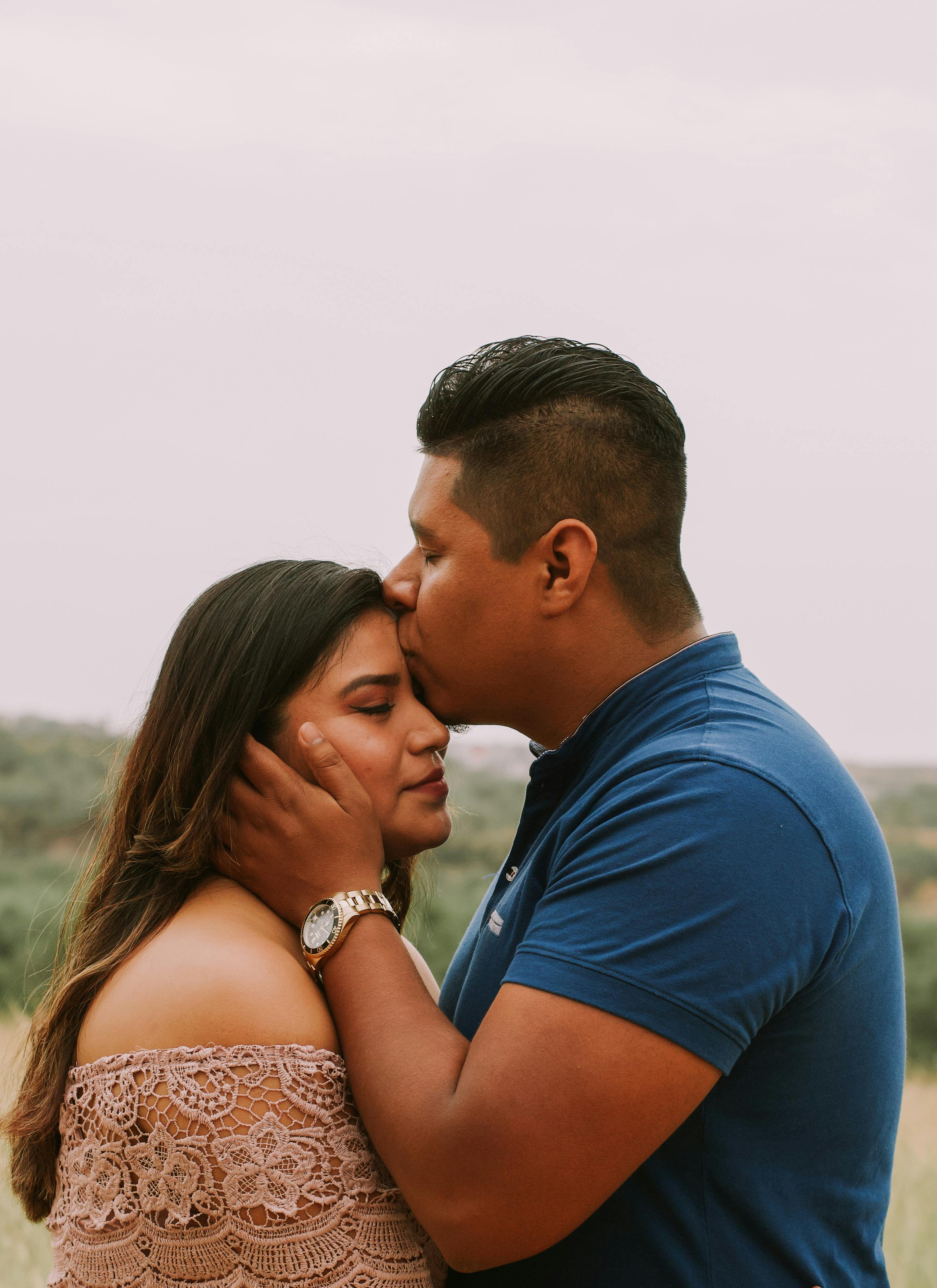 Adult Hispanic boyfriend kissing happy girlfriend · Free Stock Photo