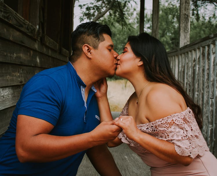 Happy Adult Couple Kissing On Terrace Of Old Shabby House