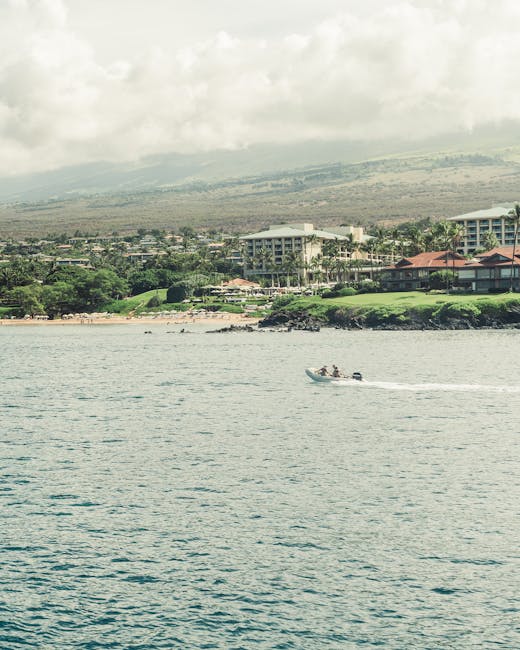 Photo by Satty Singh A serene ocean scene with a boat near the coast of Maui, Hawaii, under a cloudy sky.