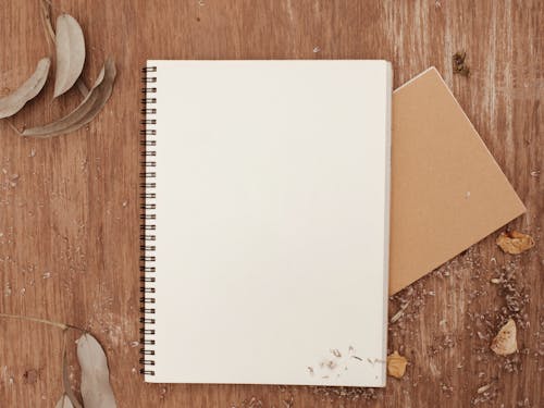 Free White Notebook on Wooden Surface Stock Photo