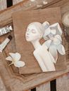 White Ceramic Angel Figurine on Brown Wooden Table