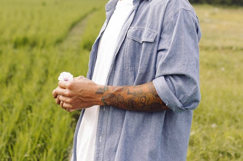 Man in Field Holding Flower