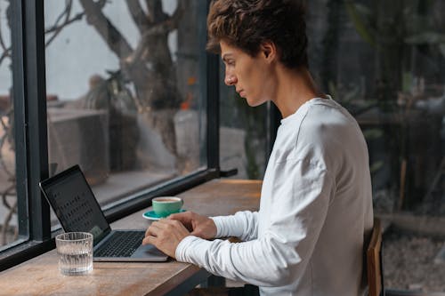 Man in White Long Sleeve Shirt Using Laptop 