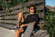 Woman in Black Tank Top and Black Shorts Sitting on Brown Wooden Bench