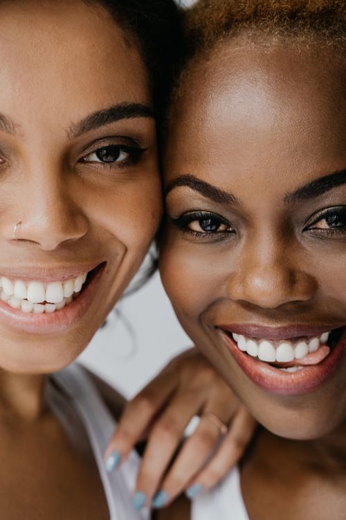 Free Portrait of two smiling women closely embracing each other, showcasing friendship and happiness. Stock Photo