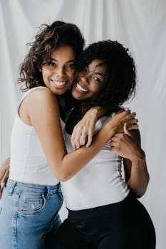 卷发微笑的女性互相拥抱，展现出友谊和幸福