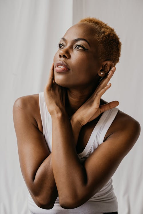 Woman in White Tank Top With Hands Around Neck Looking Up 