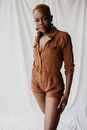 一位穿着棕色衣服、戴着耳环的自信女人的肖像