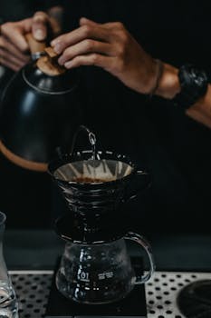Close-up of a barista expertly crafting a pour-over coffee with precision and skill.