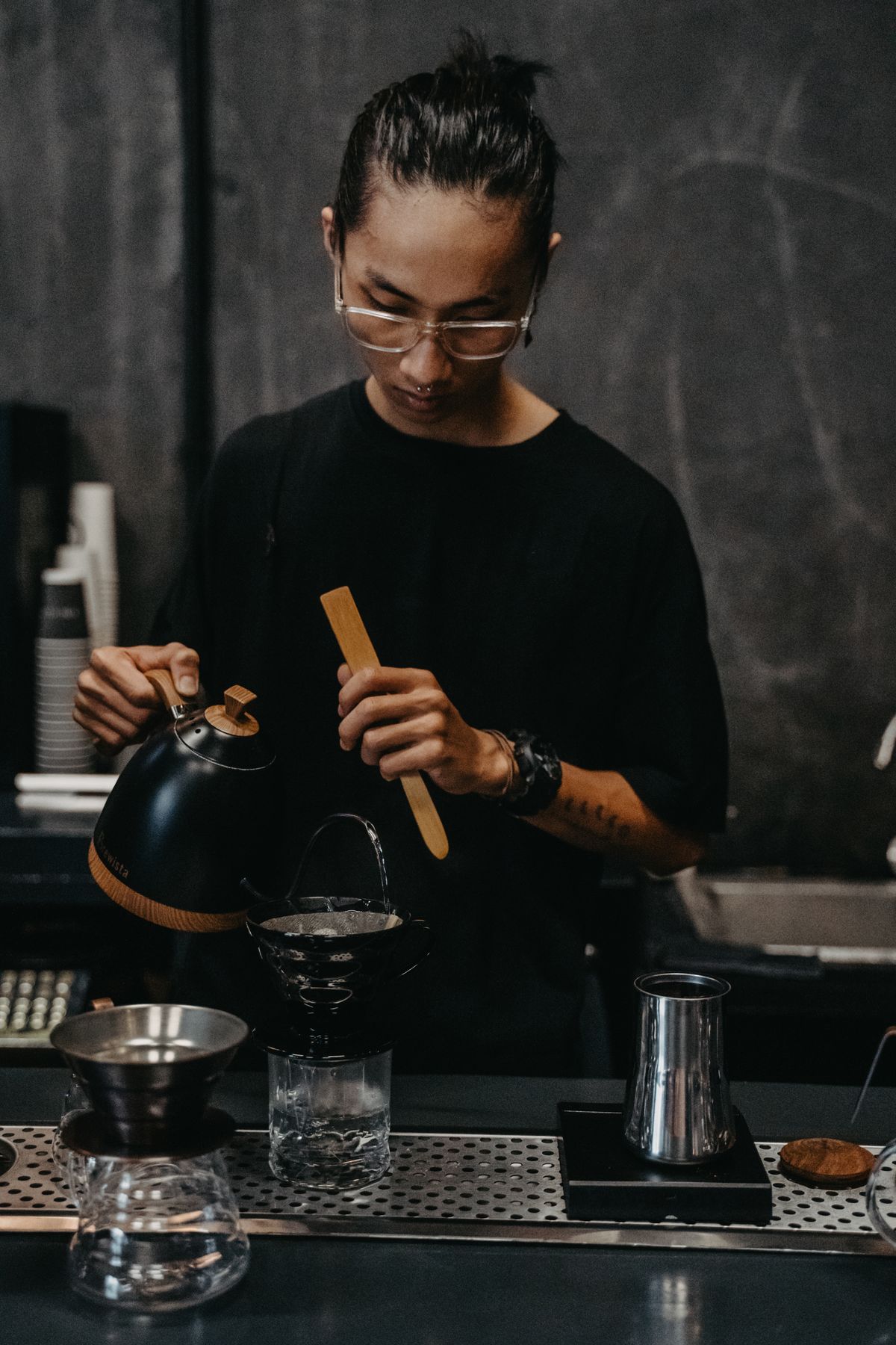 A barista preparing coffee with premium brewing equipment