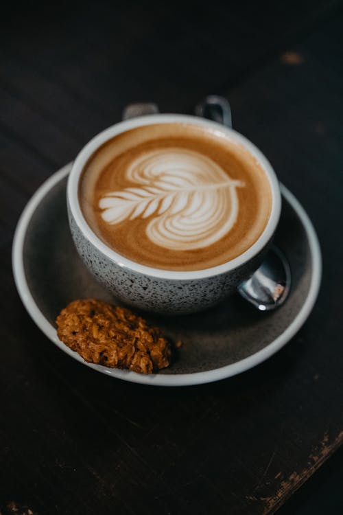 Free A Cappuccino with Latte Art and Cookie on the Side Stock Photo
