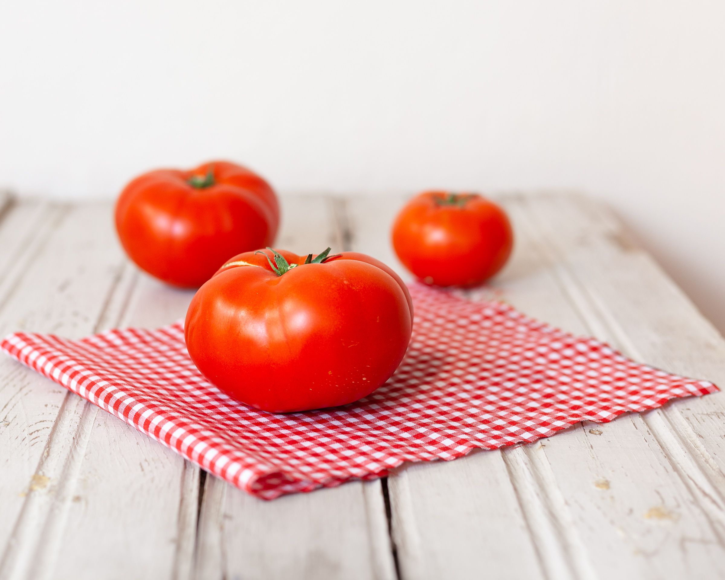 Close-up of a large beefsteak tomato with rich red color and ribbed shape