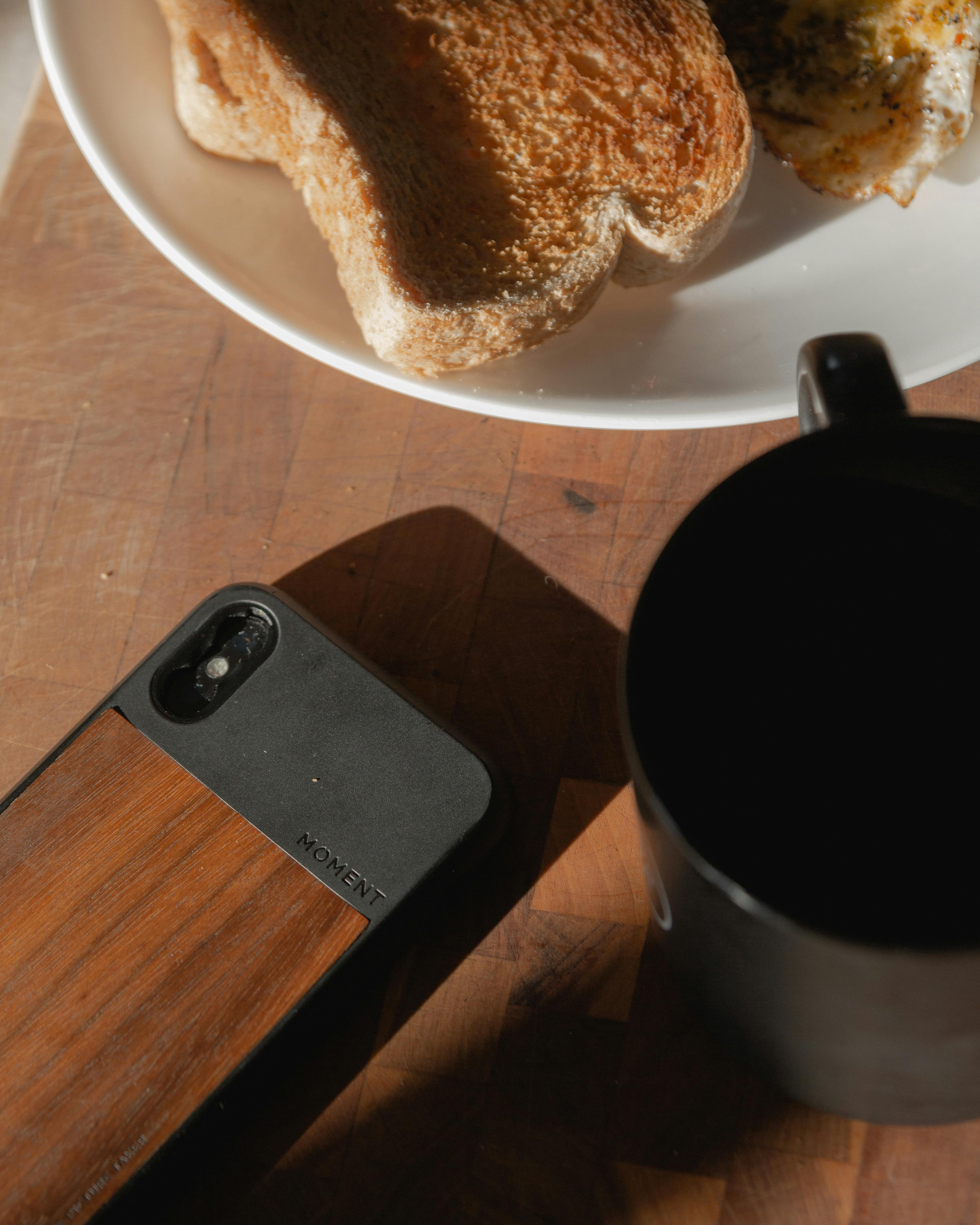 A cozy breakfast setup featuring toast, fried egg, and coffee on a wooden table.