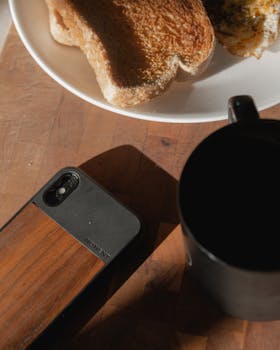 A cozy breakfast setup featuring toast, fried egg, and coffee on a wooden table.