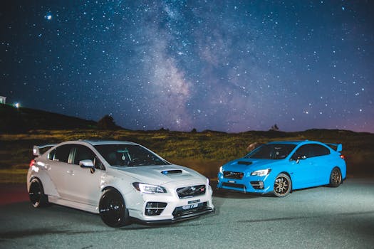 White and blue sporty cars parked under a breathtaking starry night sky, perfect for automotive enthusiasts.