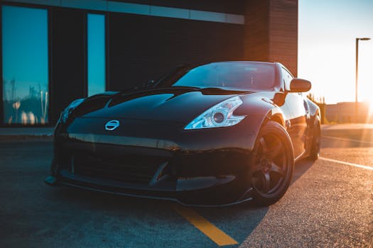 Powerful black light motor car parked outside contemporary building in light of setting sun