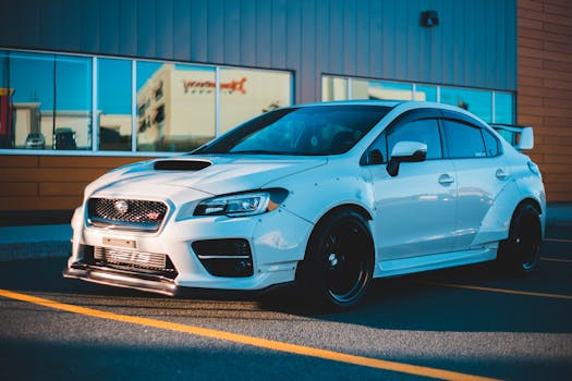 White sports car parked in an urban environment with reflective modern architecture.