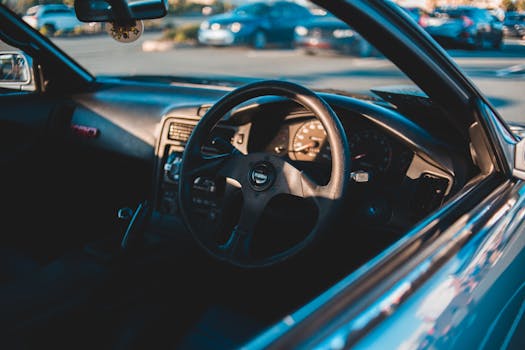 Detailed interior view of a car's dashboard and steering wheel, captured in natural sunlight.