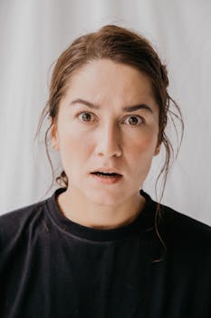 镜头特写一个女人，表情丰富，面露惊讶，背景十分简单