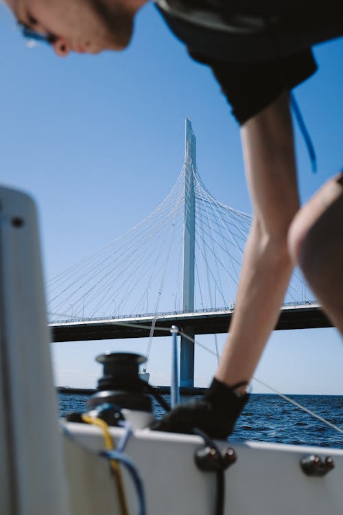 Free Person in Black Shorts and Black Shoes Standing on Bridge Stock Photo