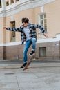 Man in Blue and White Plaid Dress Shirt Riding Skateboard