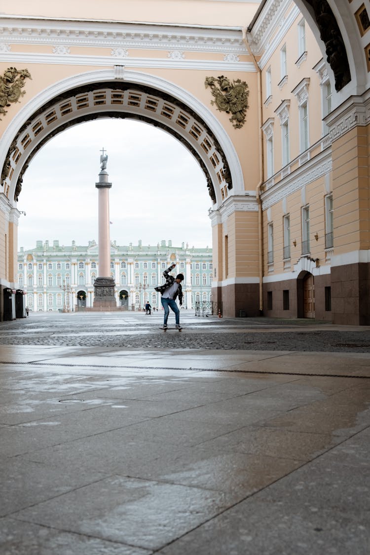 Man In Black Jacket Walking On Sidewalk