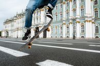 Man in Blue Denim Jeans and Black Sneakers Jumping on Black Metal Pole