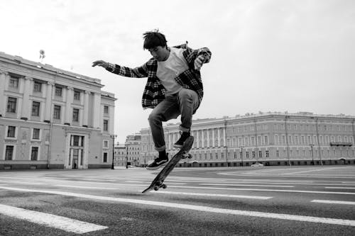 Free Man in Black Jacket and Pants Riding Skateboard in Grayscale Photography Stock Photo