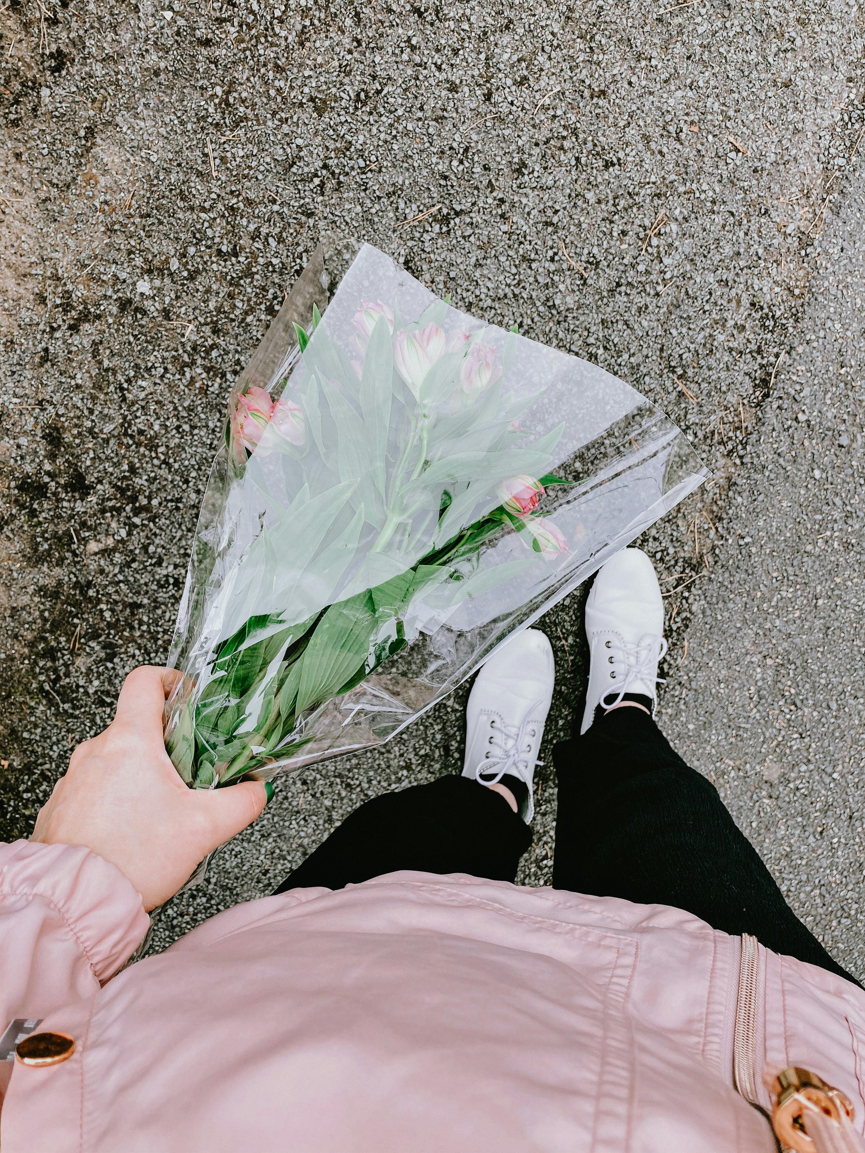 anonymous person holding bouquet of flowers