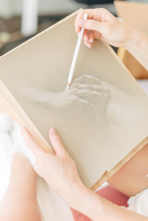 Free Person Holding a Pencil Drawing on White Paper Stock Photo