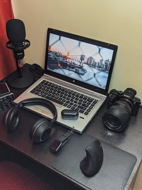 Laptop Beside Headphones and Camera