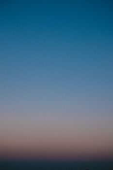Abstract background of endless bright blue cloudless sky at sundown time at dusk