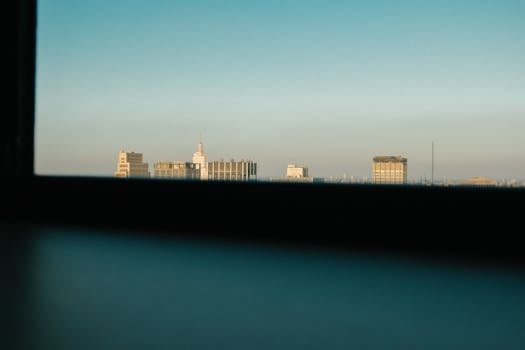 A modern cityscape view showcasing skyscrapers under a clear blue sky.