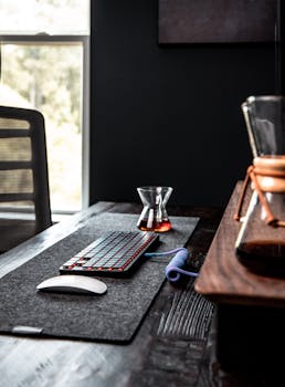 Modern workspace featuring a sleek keyboard, mouse, and coffee setup on a wooden desk.