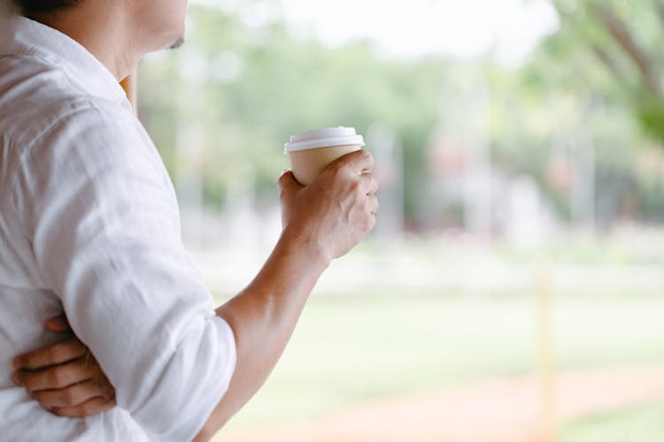 A Man Holding A Disposable Cup