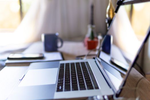 Bright home office scene with laptop, mug, and decor on a desk.