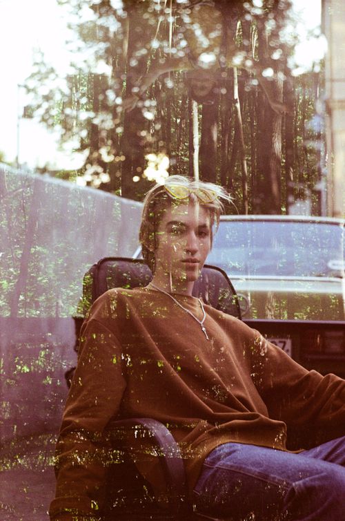 Free Double exposure of young attentive male in sweater with chain looking at camera while sitting in leather armchair near old car Stock Photo