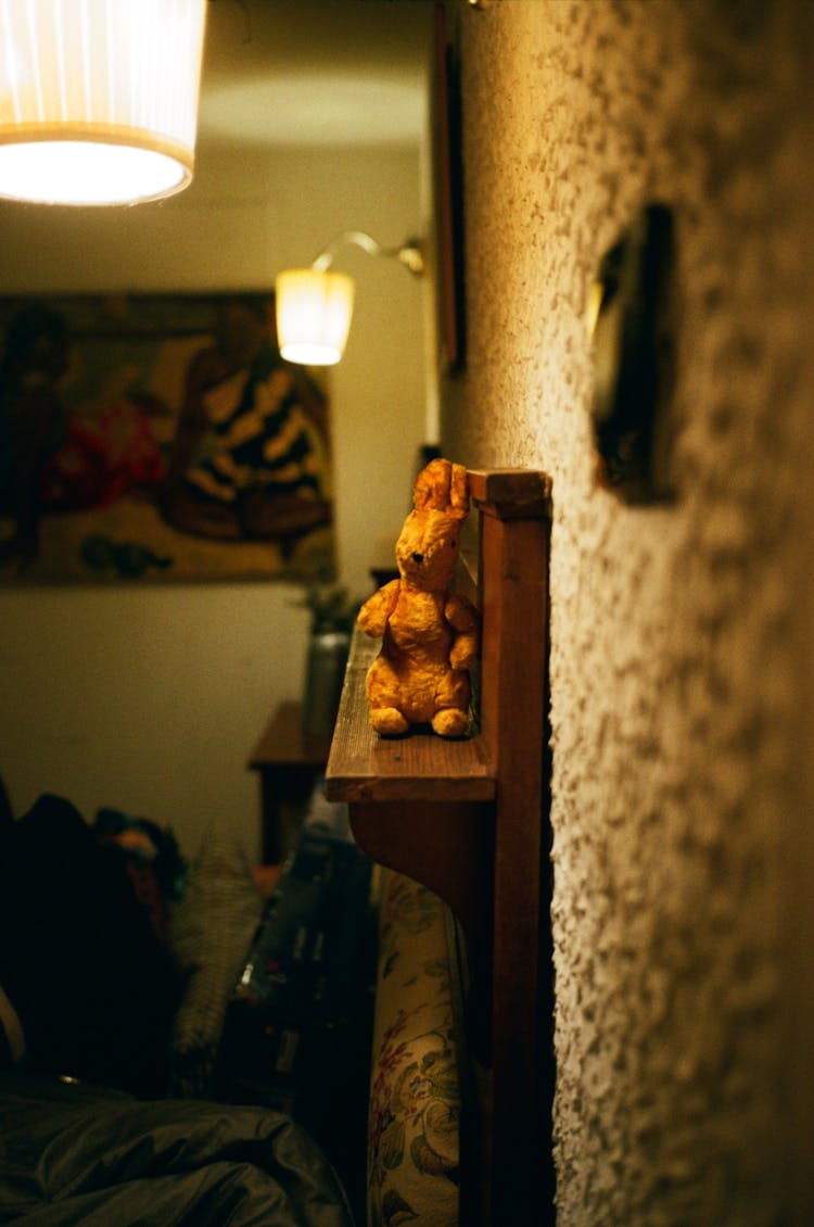 Decorative Hare On Wooden Shelf At Home With Glowing Lamps