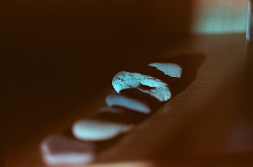 From above of assorted stones with rough and smooth surface on wooden desk in house