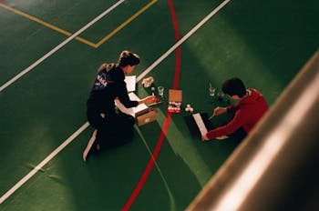 Anonymous men painting marking lines on sports court